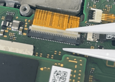 Close-up of a circuit board with electronic components and tweezers.