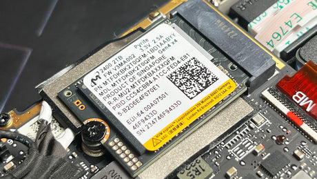 Close-up of a computer motherboard with a label and QR code