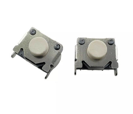Two small mechanical switches with white buttons on a white background