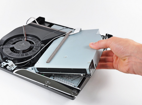 Playstation 3 CD drive replacement being installed by a person with a screwdriver.